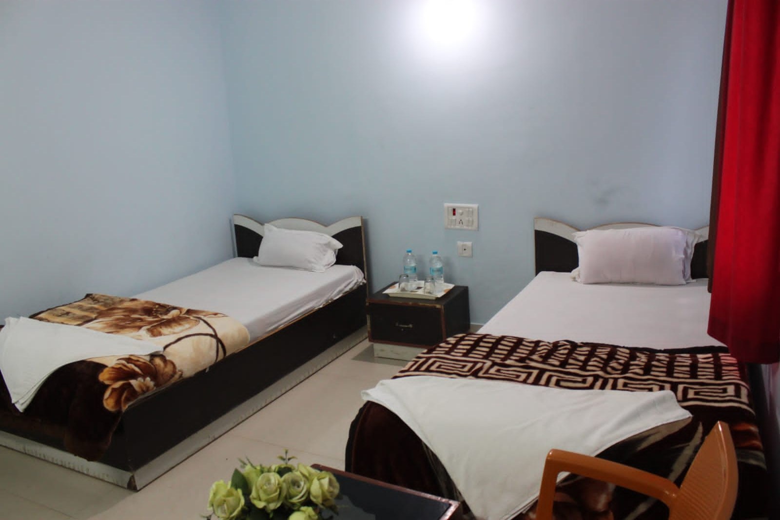 Guest room with two beds and side table at Happy International Guest House